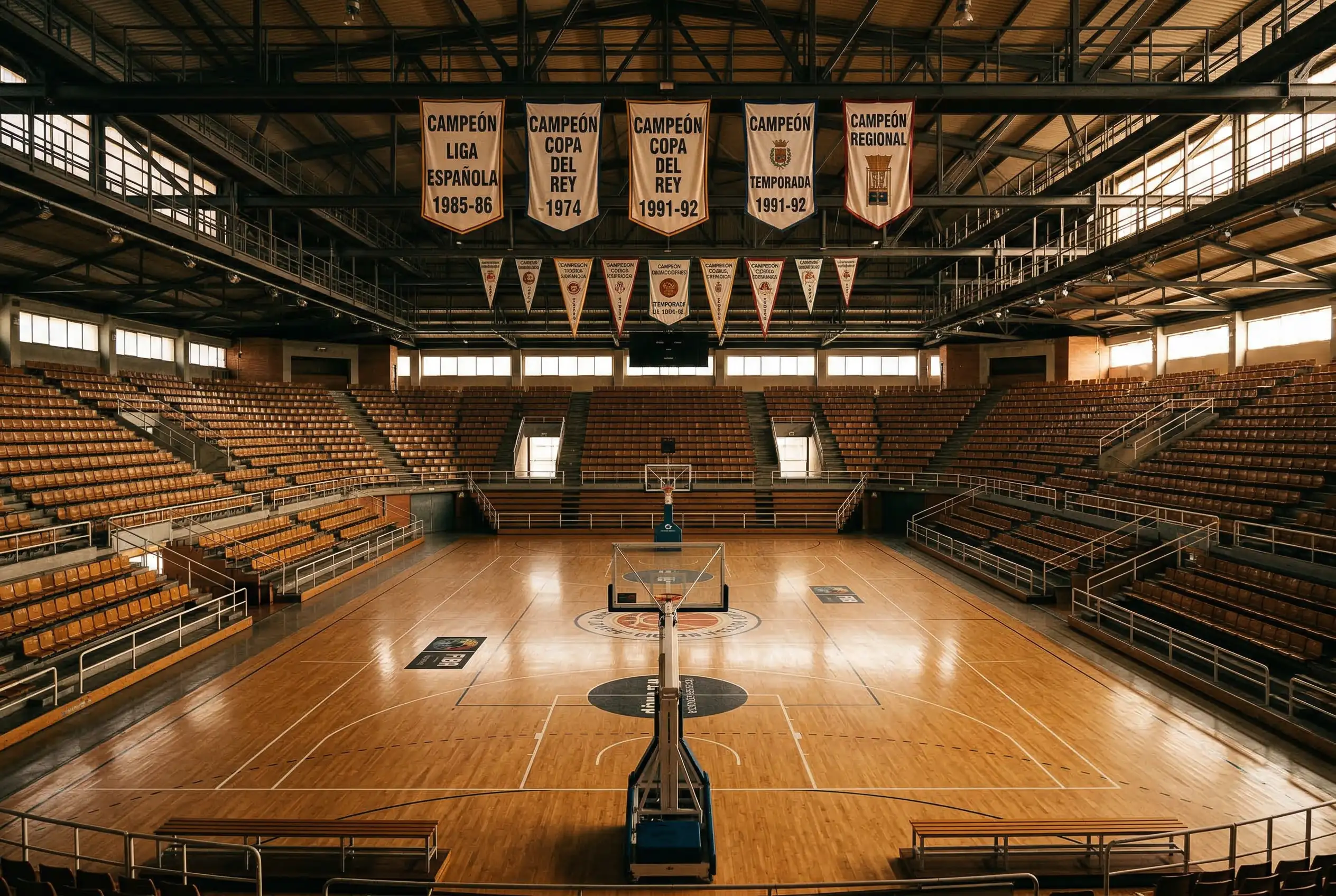 Pabellón clásico de baloncesto europeo con banderines de equipos históricos de Euroliga